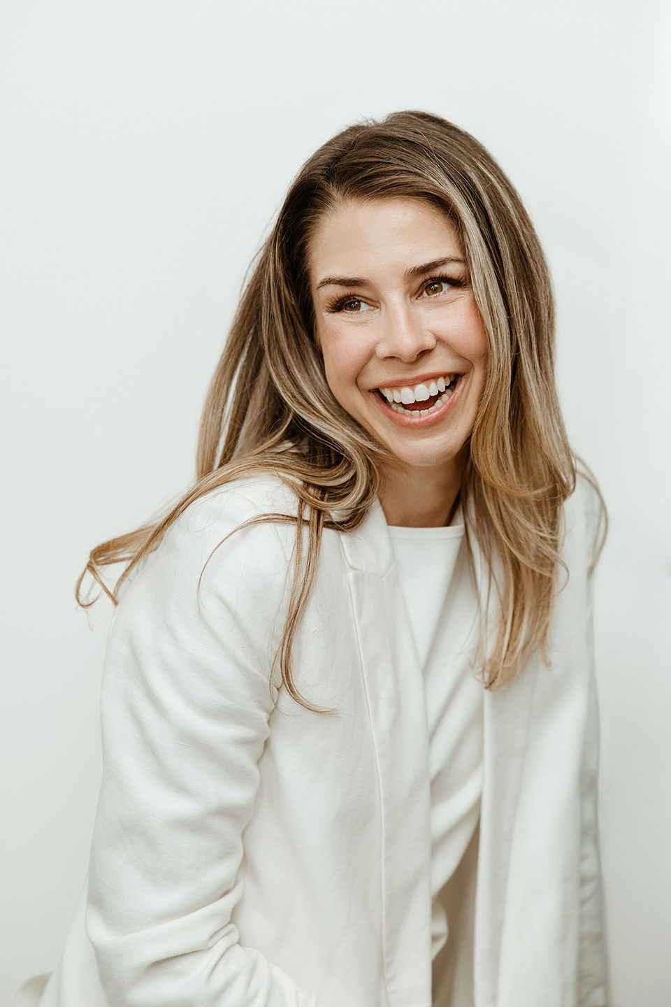 Samantha Kirby laughing in a white suit